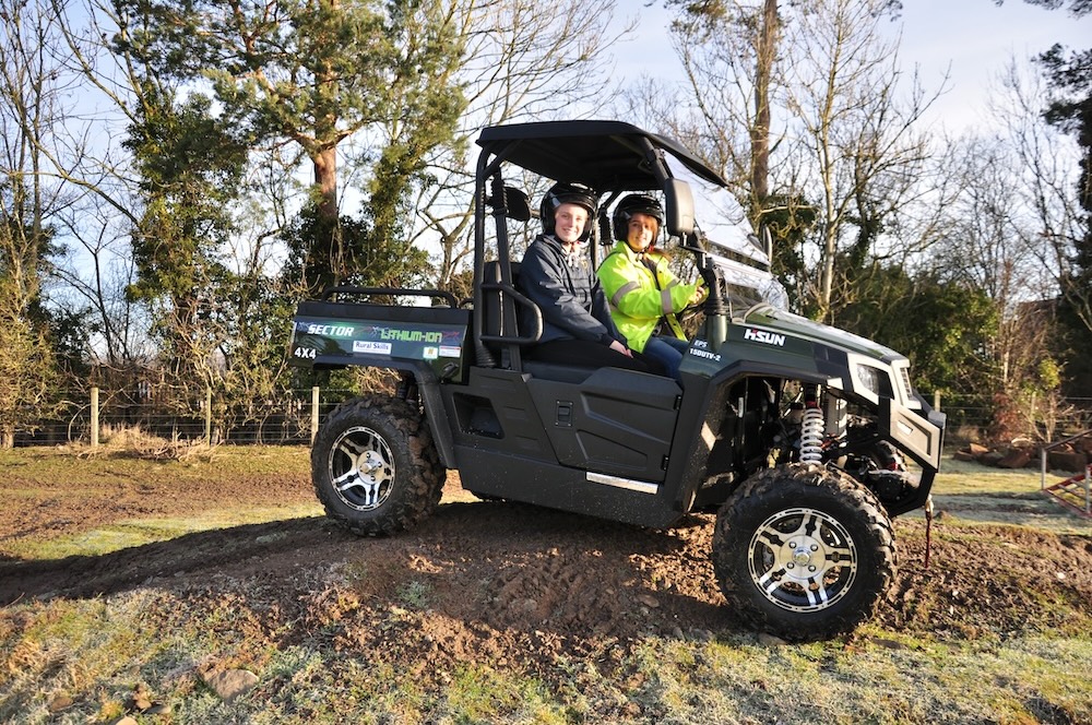 two people sitting in a utv in an outdoor setting