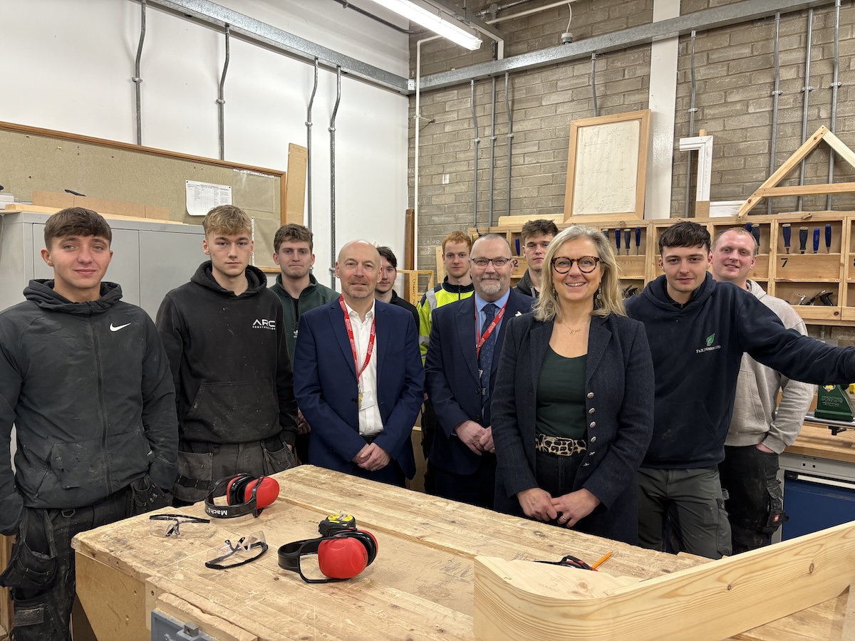 MSP Rachael Hamilton standing with a group of staff and student in a joinery workshop.