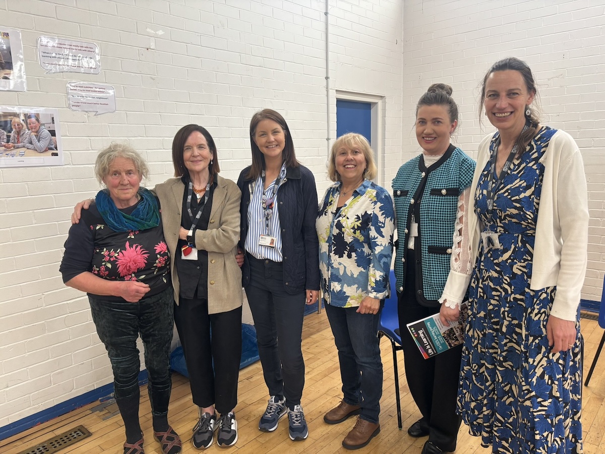 Group of six females attendees of the ESOL course standing smiling 