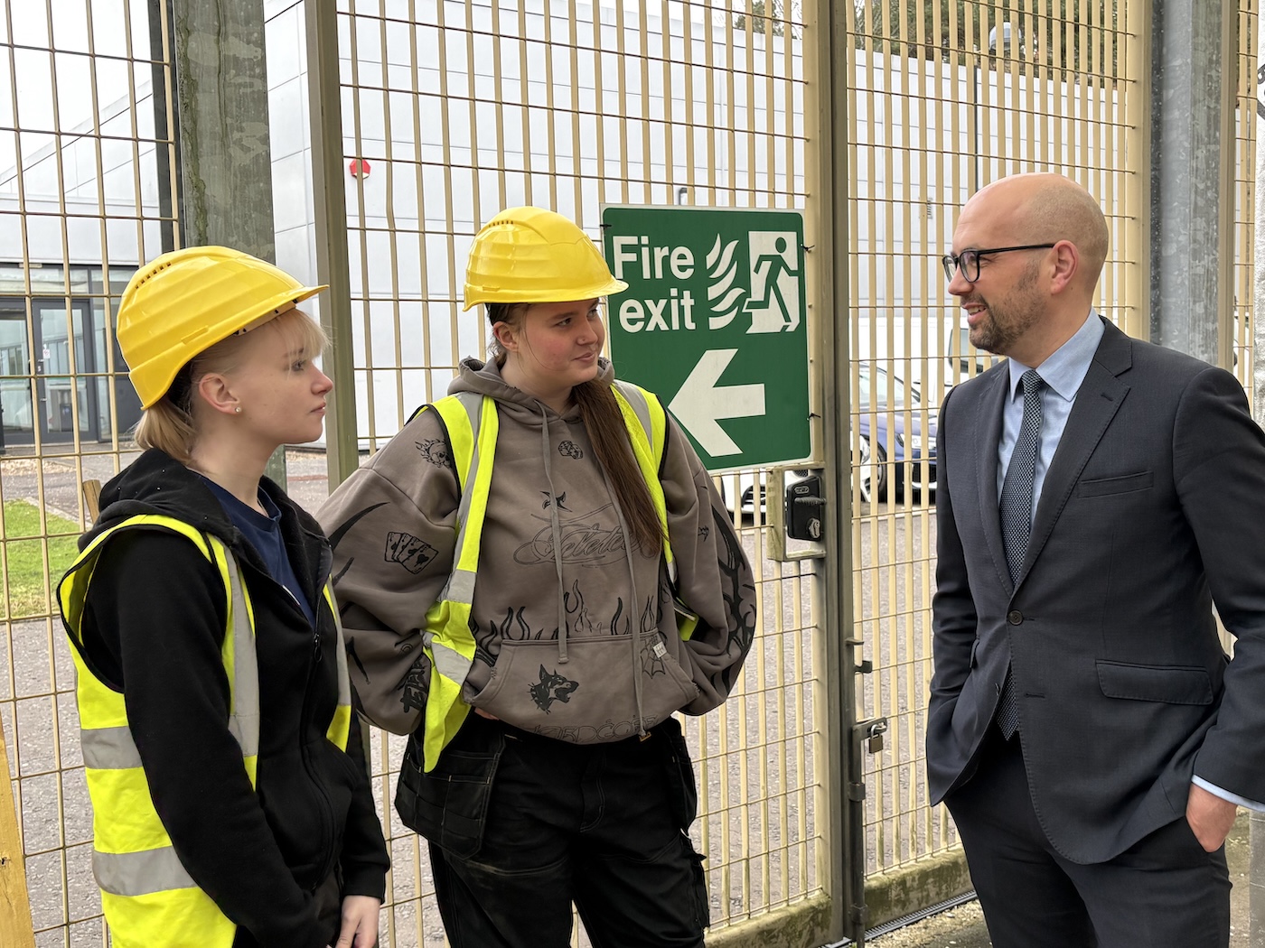 Photo of Minister Ben Macpherson speaking with joinery students in a workshop